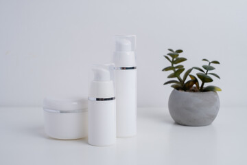 Container for cream, shampoo, toiletries, spa. Unbranded white plastic bottles. Bottle with a dispenser for cosmetic products. Skin care and beauty concept. Mockup style, copy space  
