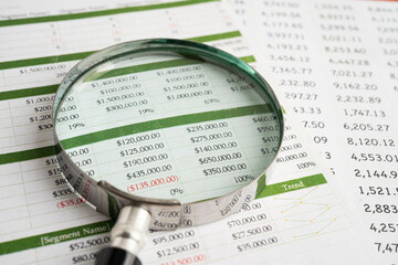Magnifying glass on spreadsheet paper.