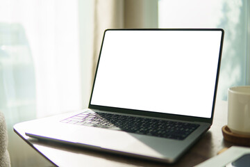 Fototapeta premium Open laptop with an empty screen on wooden desk, for app mockups or business design.