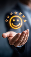 Golden emoticon with five stars floating above businessman's palm, symbolizing outstanding customer service and top tier product satisfaction