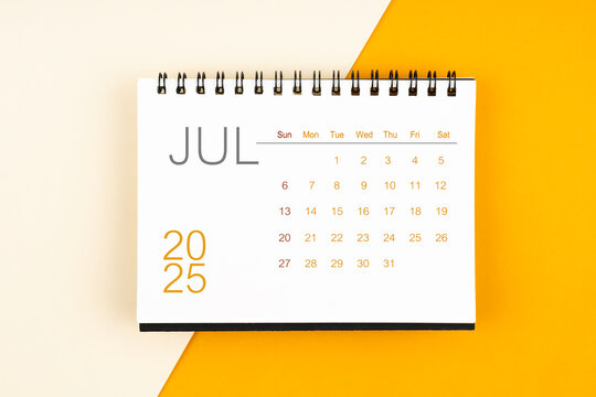 Desk calendar for July 2025 year on yellow background, Flat lay.