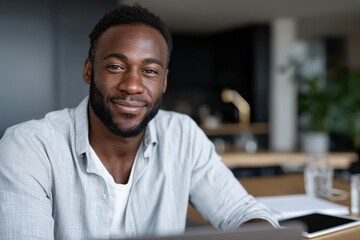 A young man exudes confidence while seated in a stylish workspace, illustrating a modern approach to professional and personal development.