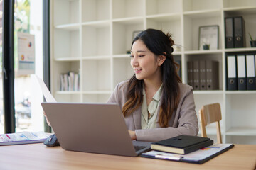 Professional businesswoman analyzing financial data and reports at her desk.