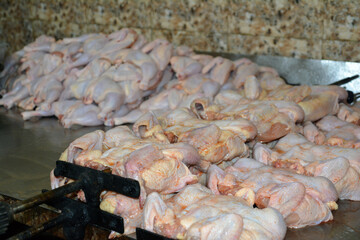 Freshly slaughtered chickens. Fresh chicken wings in market. Raw chicken on the spit in a restaurant, preparation for roasting