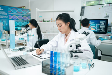 Modern medical scientists collaborate in a high-tech laboratory, analyzing chemical reactions and...