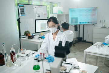 Medical research teamwork in modern laboratory using microscope and blood test tubes for DNA analysis, vaccine development showcasing scientific innovation in healthcare biotechnology