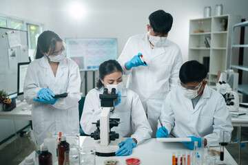 Laboratory microscope research scientists working in white lab coats conducting scientific analysis and testing biological samples for innovation in medical diagnostics and breakthroughs