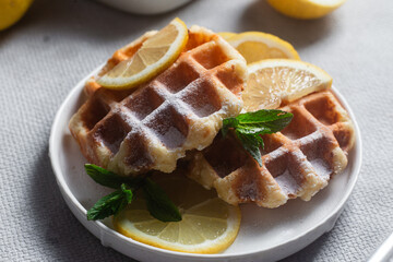 Belgian waffles made from cottage cheese with mint and lemon in a white plate on the table. Healthy breakfast