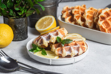 Belgian waffles made from cottage cheese with mint and lemon in a white plate on the table. Healthy breakfast