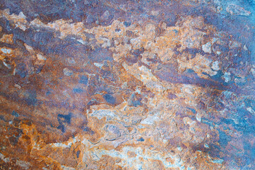 Stone surface with rusty orange and brown texture.