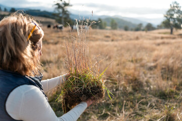 farmer holding soil full of microorganisms. sustainable regenerative agriculture, women in...