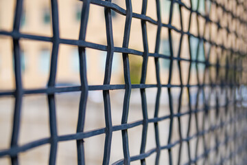 Symmetrical metal grille. metal fence detail. Selective focus.