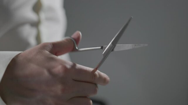 A man holds scissors and repeatedly opens and closes them. Simple hand movement showing tool usage, focus, and minimalism in everyday actions