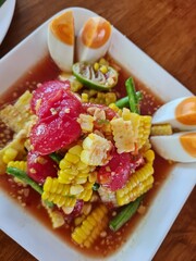 Corn salad with salted egg on a white plate
