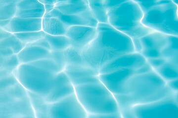 Blue swimming pool water surface and ripple wave background. Summer abstract reflection.