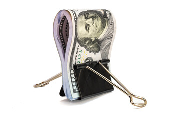 Bundle of hundred-dollar bills held by a black binder clip. Concept of savings, finance, or...