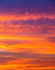Obraz premium A breathtaking sunset paints the sky with vibrant hues of orange, pink, and purple, as fluffy clouds drift lazily, framing the glowing sun on the horizon.