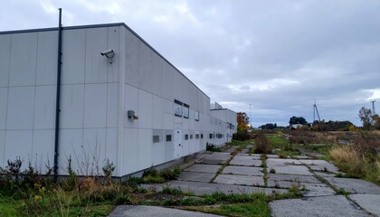 Abandoned Industrial Building Surrounded by Overgrown Vegetation