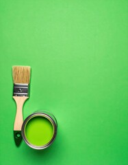 A vibrant green wall serves as a backdrop for a paintbrush, its bristles slightly dipped in bright paint, suggesting a creative and artistic atmosphere.