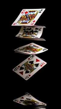 Floating Playing Cards with Reflection on Black Background