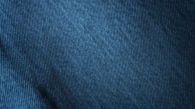 Looped blue denim fabric texture with diagonal pan motion. Clothing jeans textile video background.