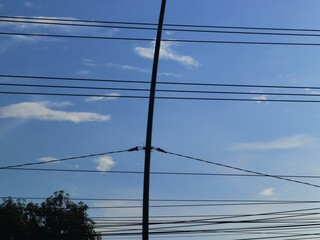 high voltage power lines against blue sky