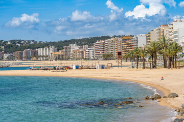 Calonge beach showing hotels, boats, palm trees and blue sea in catalunya, spain