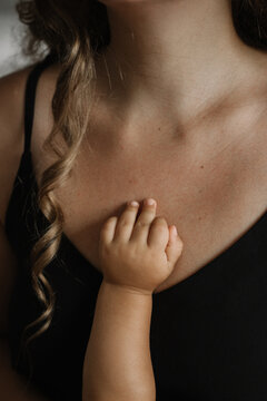 Kids, newborn baby hand on mothers breast close up