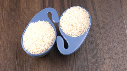 Healthy food. Wooden bowl with parboiled rice on white background. Top view, copy space, high resolution product.
