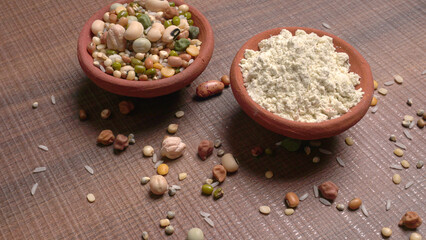 Uncooked pulses,grains and seeds in colourful bowl over wooden background. selective focus
