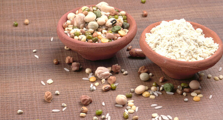 Uncooked pulses,grains and seeds in colourful bowl over wooden background. selective focus
