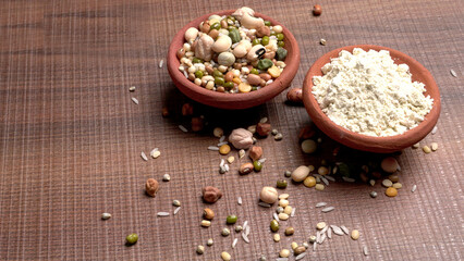 Uncooked pulses,grains and seeds in colourful bowl over wooden background. selective focus
