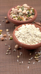 Uncooked pulses,grains and seeds in colourful bowl over wooden background. selective focus
