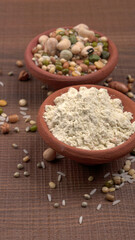 Uncooked pulses,grains and seeds in colourful bowl over wooden background. selective focus
