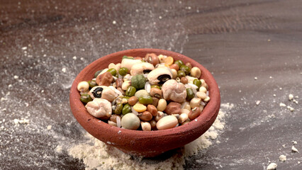 Uncooked pulses,grains and seeds in colourful bowl over wooden background. selective focus
