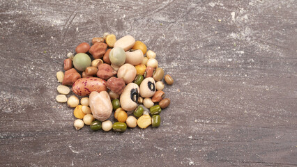 Uncooked pulses,grains and seeds in colourful bowl over wooden background. selective focus

