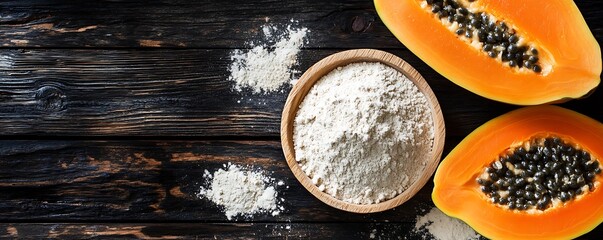 Papaya flour in bowl, alongside halved papayas on dark wood