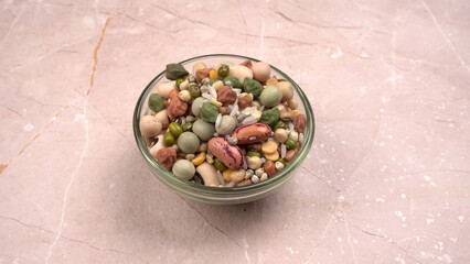 Uncooked pulses,grains and seeds in colourful bowl over wooden background. selective focus
