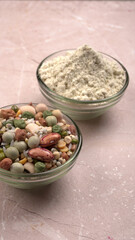 Uncooked pulses,grains and seeds in colourful bowl over wooden background. selective focus