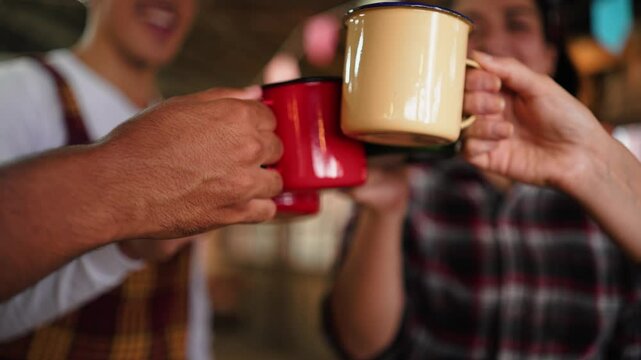 Close-Up Celebration with Steel Mugs at Brazilian June Festival Toast. Friends Raising Colorful Cups in a Festive Salute at Festa Junina Gathering