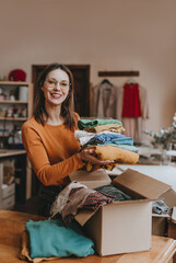 Female volunteer sorting old clothes for charity or converting discarded materials