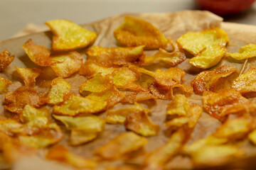 Savor the delightful experience of freshly made, crispy potato chips, beautifully arranged on parchment paper, ideal for serving