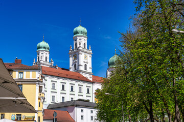 Fototapeta premium St. Stephans cathedral in Passau, Germany is an old white church with green metal domes on top of the towers