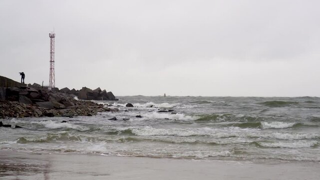 Baltic seascape. Entrance to Klaipeda seaport. Dark and stormy waves rolling and crashing. Slow motion footage. Lithuania.