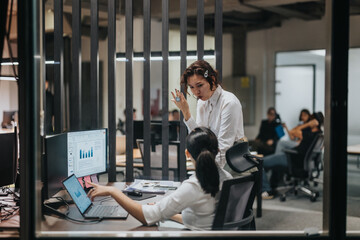 Two business professionals engaged in a discussion over data analytics in a contemporary office. The setting features technology and collaborative teamwork, emphasizing focused communication in a