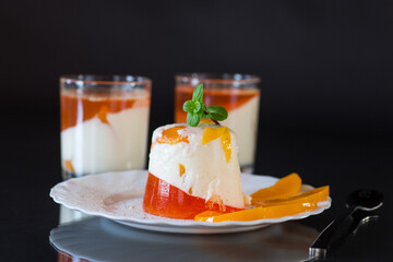 Panna cotta dessert with fruit jelly and mint