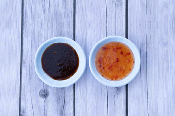 top view.chilly Sauce and teriyaki Sauce on top wood.