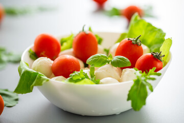 Delicious composition with mozzarella, cherry tomatoes and greens