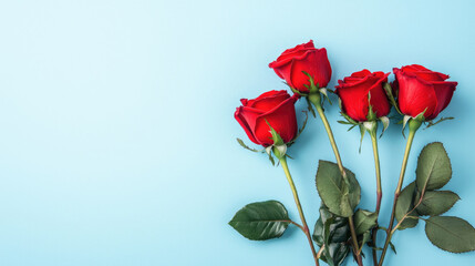 Obraz premium Four vibrant red roses with green stems, against a light blue backdrop