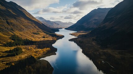 Naklejka premium Aerial view of a diverse landscape featuring a winding river flowing through a mix of green and autumn-colored trees.